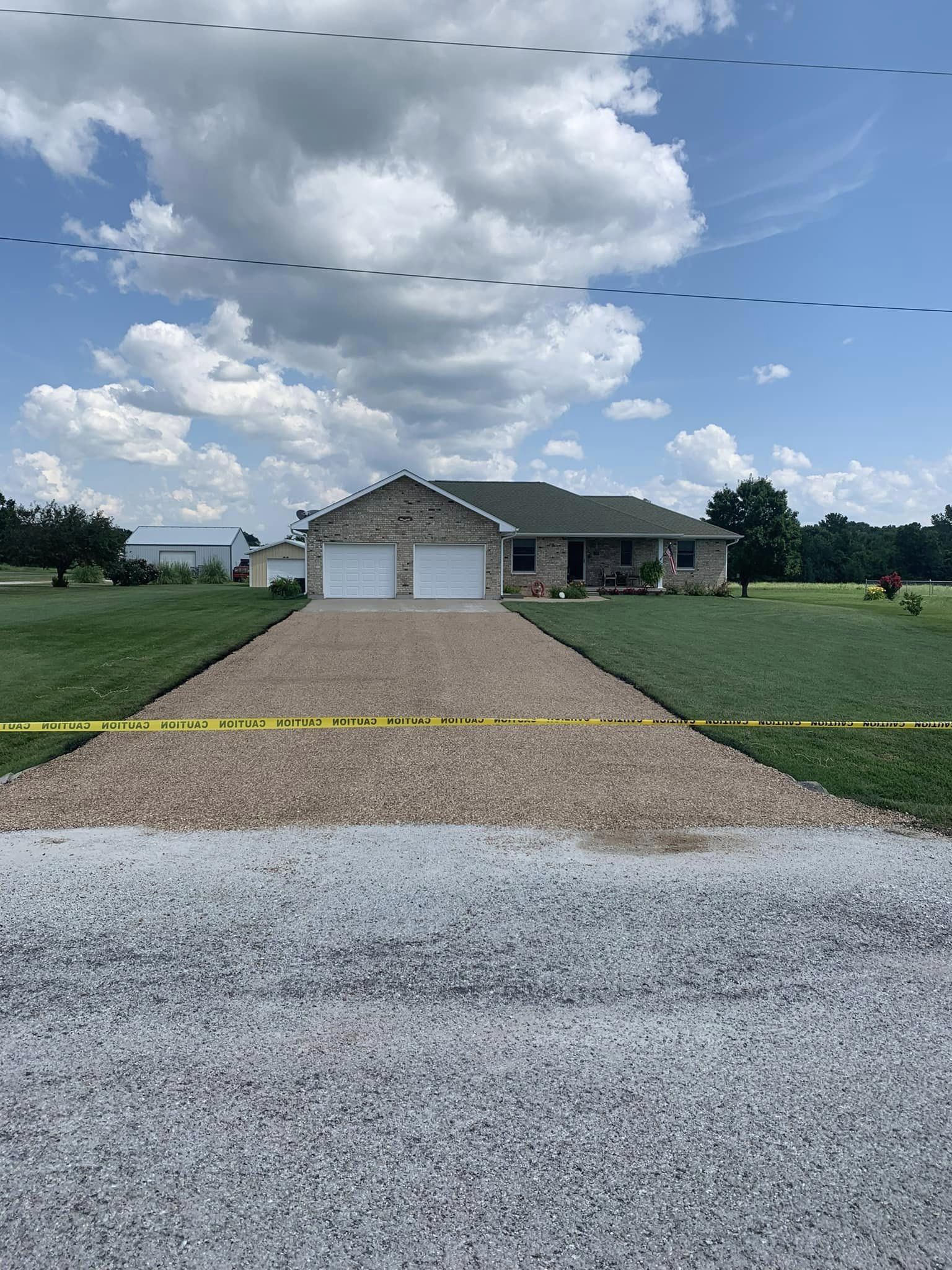 Chip seal driveway leading up to a southern brick home