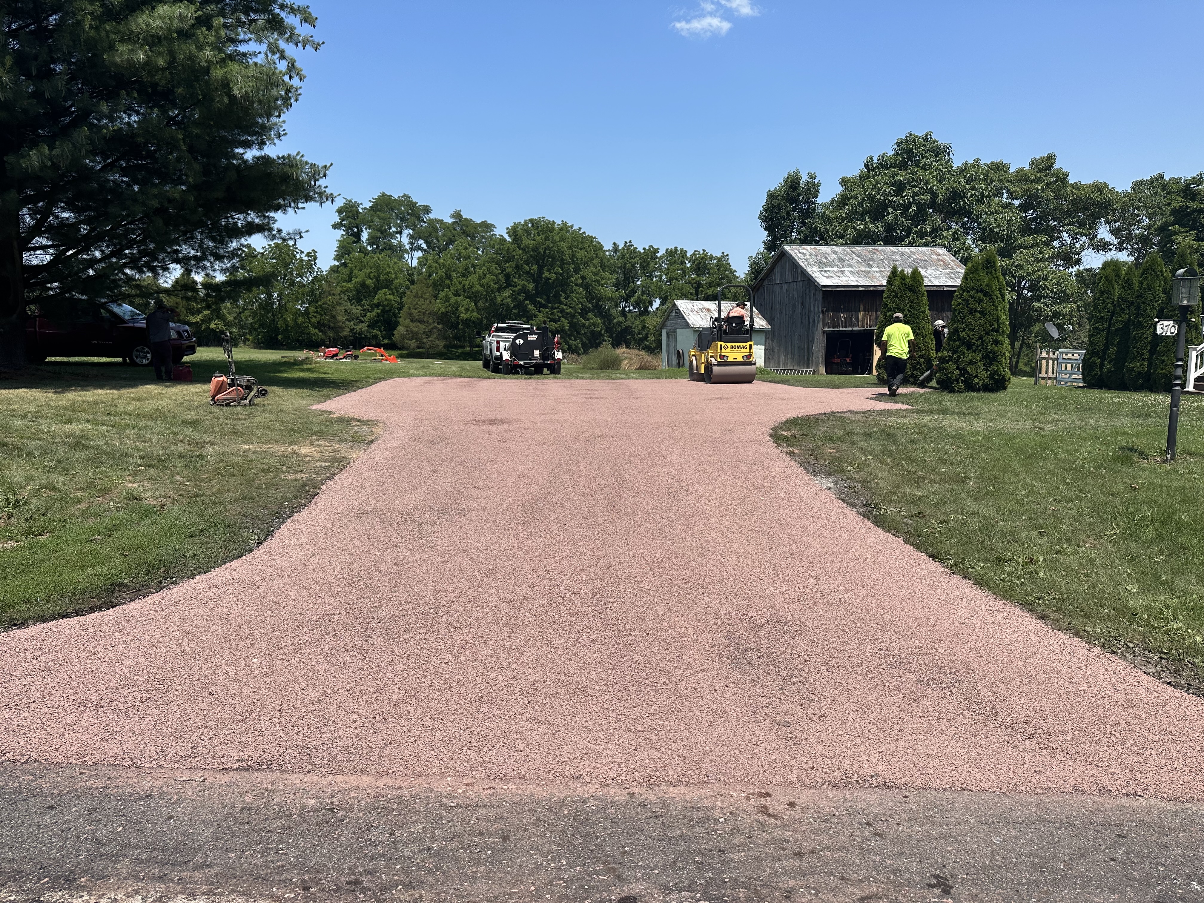 Chip seal driveway at a brick home with fall foliage