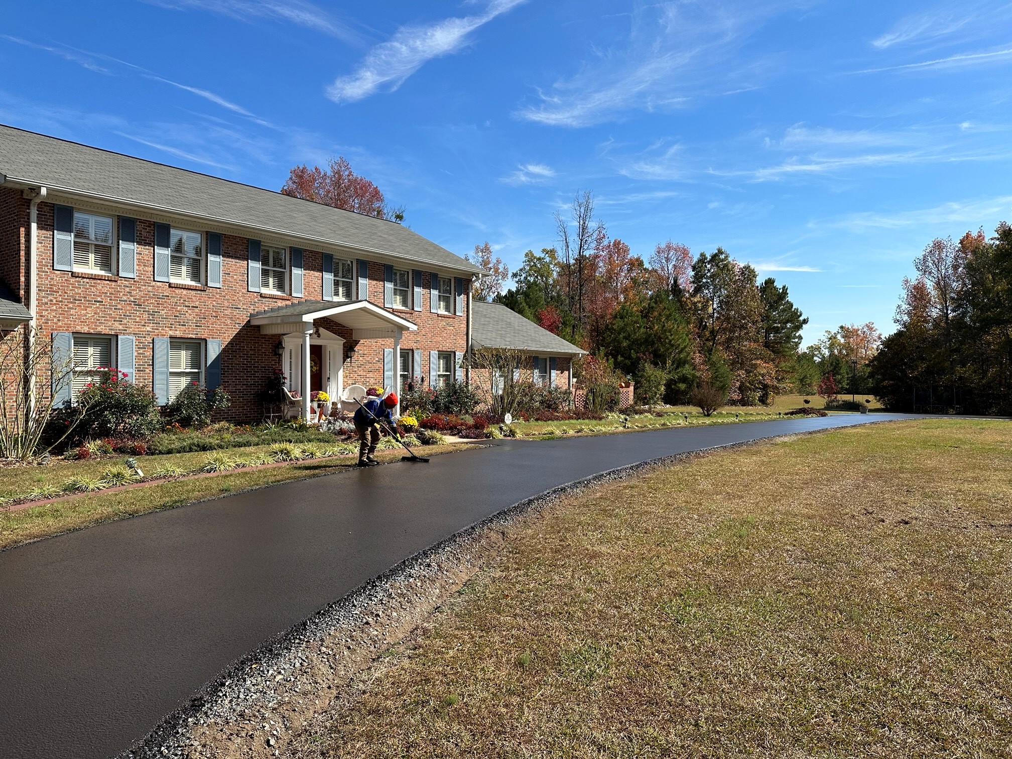 Sealcoating a residential driveway with brick home